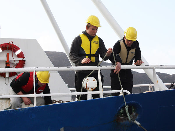 Foto av tre elevar ombord på opplæringsfartøyet Skulebas. Foto: Måløy vidaregåande skule