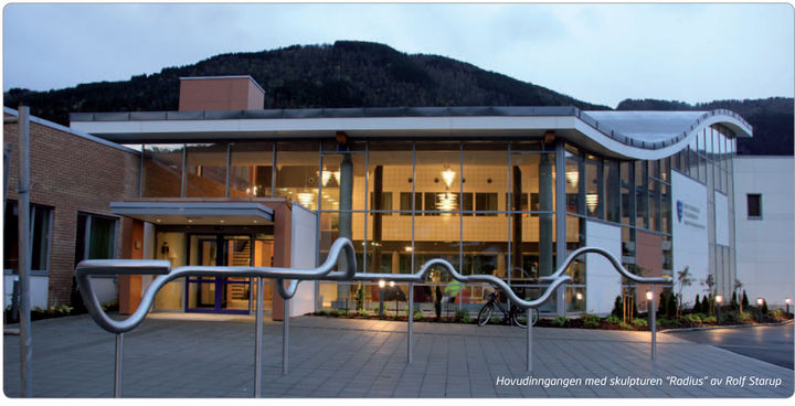 Bilete syner hovudinngangen til Sogndal vidaregåande skule med skulpturen "Radius" av Rolf Starup