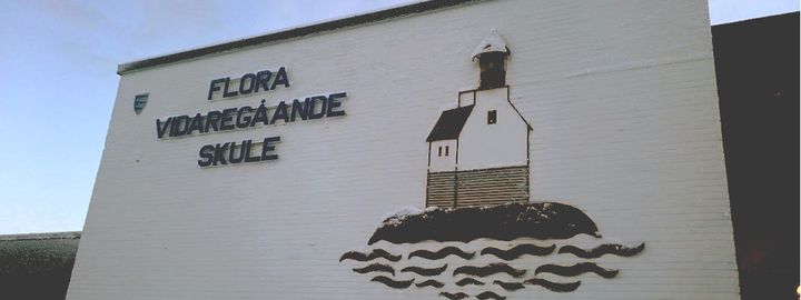 Bilde av skulen sin logo som vist frå framsida av bygget med logo av stabben fyr Bilde av skulen sin logo som vist frå framsida av bygget med logo av stabben fyr