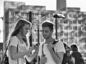 People on Alexanderplatz I. Foto: Sascha Kohlmann (flickr CC BY-SA) Ei jenta og ein gutt med mobilen