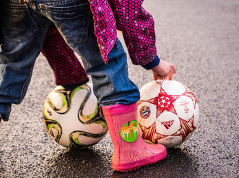Rubber boot and balls. Foto: Sascha Kohlmann (flickr CC BY-SA) Beiner til eit barn som spiller med to ball