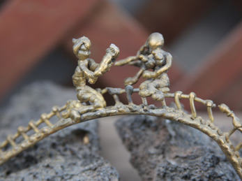 April creative. Foto: Devon Christopher Adams (flickr CC BY-NC) Miniaturkunst av metal, to menesker på brua