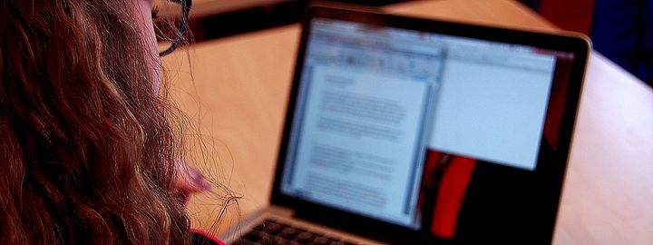 Foto: Flora vgs elev forran pc med ei skriveoppgåve