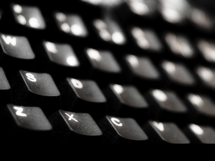 Nærbilete av svart tastatur med kvite bokstavar