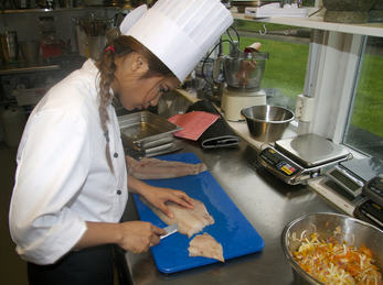 Bilete syner elev ved Restaurant- og matfag som fileterer fisk 1030700980 Bilete syner elev ved Restaurant- og matfag som fileterer fisk