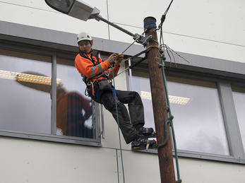 Bilete syner elev ved Elektrofag som monterar i stolpe. 1030700980 Bilete syner elev ved Elektrofag som monterar i stolpe.