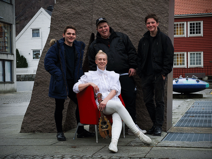 Thea Hjelmeland, Adrian Nilssen, Joakim Ese og Krister Ese Musiker Thea Hjelmeland utanfor Høyanger samfunnshus med 3 elevar bak seg