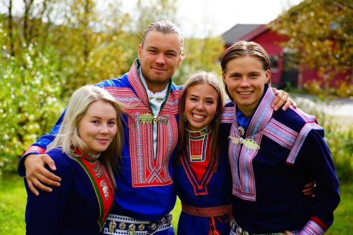 To gutar og to jenter ikledd fire ulike samiske kofter
