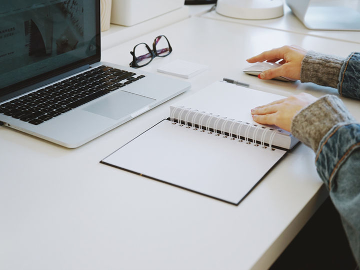 Foto av STIL frå Unsplash Nærbilete av hender, ei kvinne som jobbar framfor PC