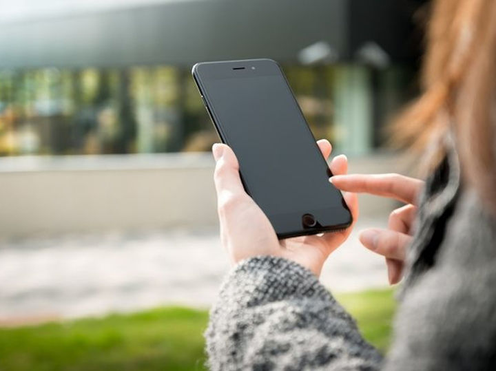 Bilete syner ei som tastar på ein mobiltelefon