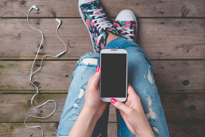 Ungdom som sit med ein mobiltelefon på fanget