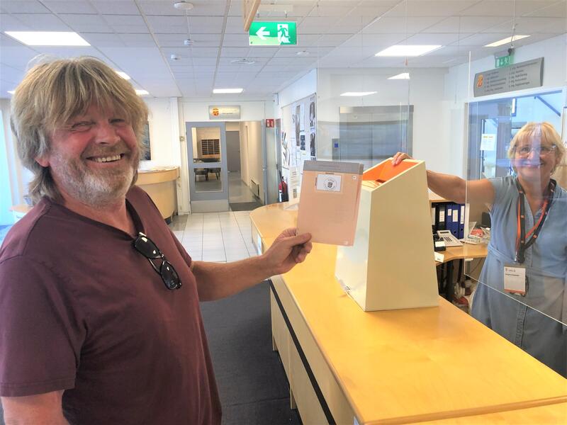 Jan Arild Karlsen leverer stemmeseddelen mens Britt Pedersen passer på at legitimasjonen er i orden.