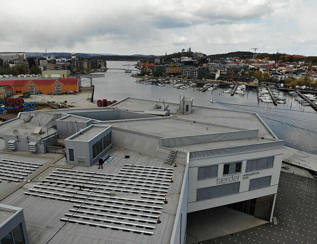 Dronebilde som viser solcelleanlegget på taket av Færder videregående skole, med kanalen i Tønsberg, Kaldnes og byen i bakgrunnen. Foto: Erik Moen