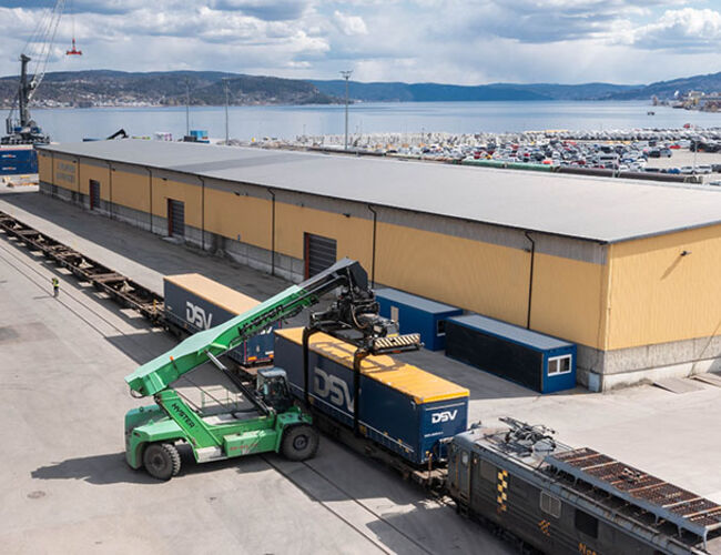 KORTREIST. Det er kort vei fra Norgips-fabrikken (som kan skimtes bak til høyre på bildet) og til Drammen havn der containerne med ferdige produkter nå lastes over på jernbane for videre transport. Foto: Norgips