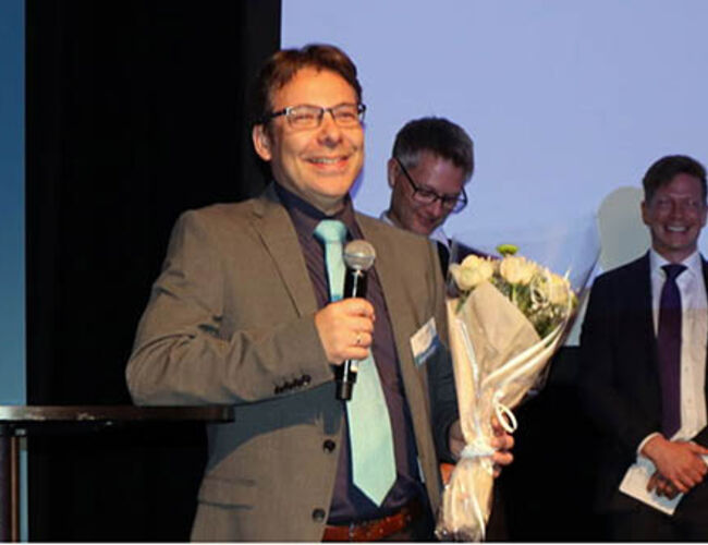 En glad og rørt Steffen Møller-Holst takker for tildelingen av Hydrogenprisen 2018. I bakgrunnen Anders Ødegård og Bjørn Simonsen i juryen. Foto: Hydrogen.no