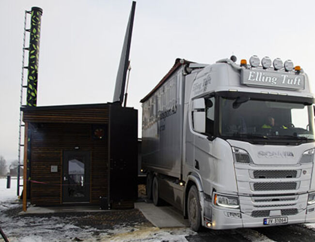 Når flis skal leveres åpner man dørene til siloen, løfter opp taket hydraulisk, og så kan man tippe med en fullastet lastebil. Foto: Tekniske Nyheter