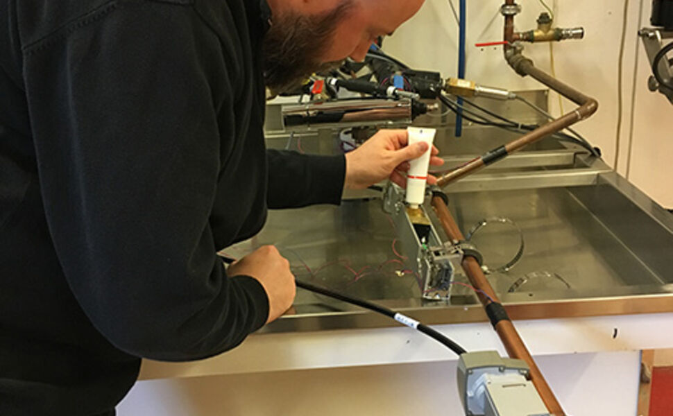 Bjørn Ludvigsen tester måleutstyr for bruk av varmtvann hos SINTEF Byggforsk. Utstyret vil nå plasseres i utvalgte bygg. Foto: Sintef