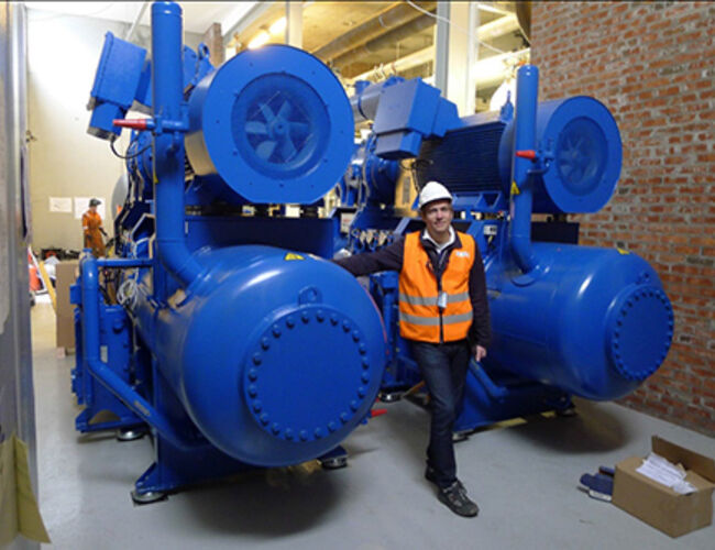 Bildet er fra installeringen av den nye 5 MW varmepumpen i fjernvarmsentralen til Oslo Lufthavn. Personen på bildet er Frode Fjelstad som er disiplinleder for RIV (rådgivende ingeniør vvs) i T2-prosjektet. Foto: Halvard Felde, prosjektleder Termisk energi