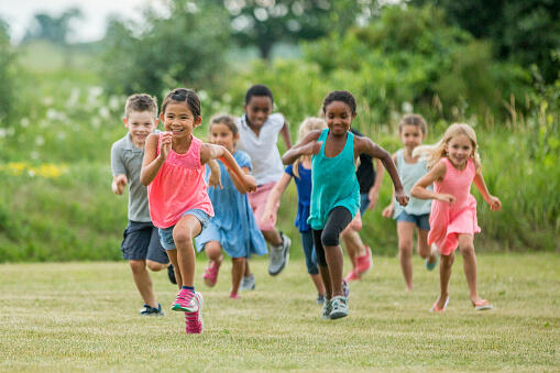 Glade barn som løper på gresset