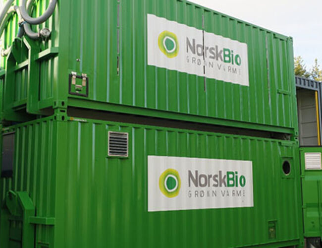 Den vannbårne løsningen til Norsk Bio. Containeren i bunnen inneholder kjeler, elektronikk, pumper etc., mens containeren på toppen fungerer som en silo, som tar cirka 17 tonn med pellets. Foto: Norsk Bio
