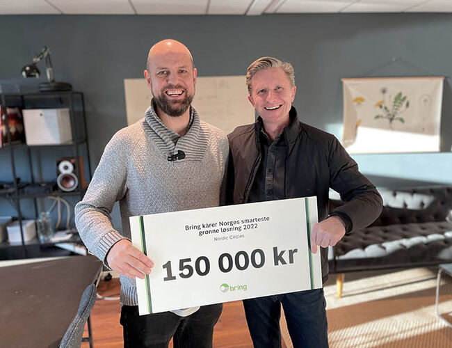 Styreleder i Nordic Circles, Fredrik Barth (t.v.), ble overrasket med premien på 150.000 kroner av bærekraftdirektør Colin Campbell i Posten og Bring. Foto: Posten Norge