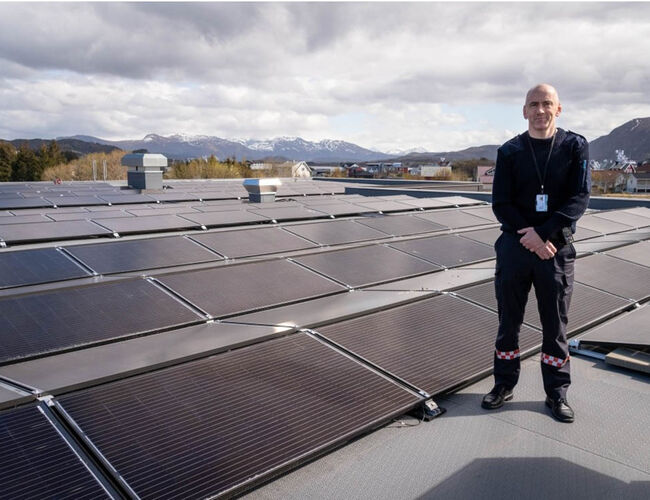 Finn Ulvund, brannsjef i Herøy, viser fram 450 kvadratmeter solcellepanel på taket av den nye brannstasjonen på Eggebønes i Herøy kommune. Foto: Møre og Romsdal fylkeskommune