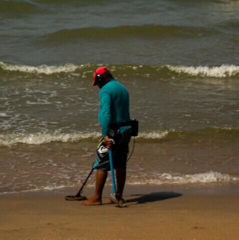 Mann med metalldetektor på stranda. Foto:Unsplash