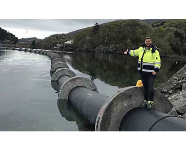 Prosjektleder Martin Horne viser frem et 2,2 km langt rør som torsdag 11. mai ble slept fra Sotra til Puddefjorden, der sjøvann skal brukes til kjøling av blant annet Media City Bergen. Foto: Silje Kalve