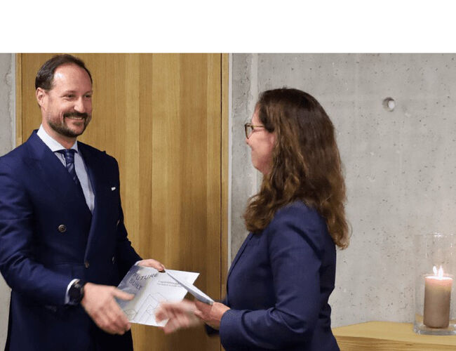 Statssekretær Gunn Karin Gjul fra Kommunal- og distriktsdepartementet overrekker Futurebuilt-plakett til H.K.H. Kronprins Haakon. Foto: Liv Osmundsen/Det kongelige hoff