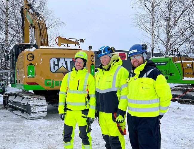 Ladepause: Svein Harald Liodden fra Gjerdalen Entreprenør, Morten Berg-Solbakken fra Bane NOR og Ole Christian Rognlien fra Baneservice foran de elektriske gravemaskinene. Lunsjpausen utnyttes til lading. FOTO: Olav Nordli, Bane NOR