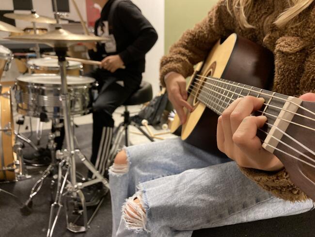 2 personer som spiller instrumenter, en på gitar en på trommer