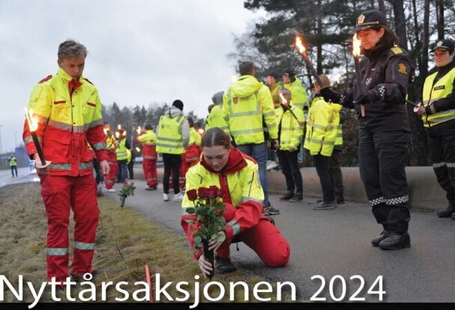 Markering av alvorlige trafikkulykker. Mange personer til stede i gule jakker/ refleksvester. Politi og ambulansepersonell holder fakler, og en setter røde roser i veikanten.