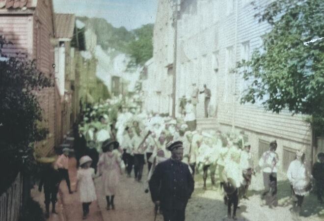 Bilde av 17. mai tog som går forbi Andorsengården. Fra 1911.