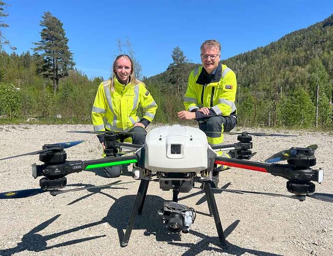 − Bruk av drone er en del av nettselskapets kontinuerlige arbeid for å sikre en pålitelig strømforsyning, sier sier Liv Hege Ketilsdotter Homme, vedlikeholdsingeniør distribusjonsnett i Glitre Nett, som viser frem dronen til Tore Morten Wetterhus, administrerende direktør i Glitre Nett. Foto : Glitre Nett
