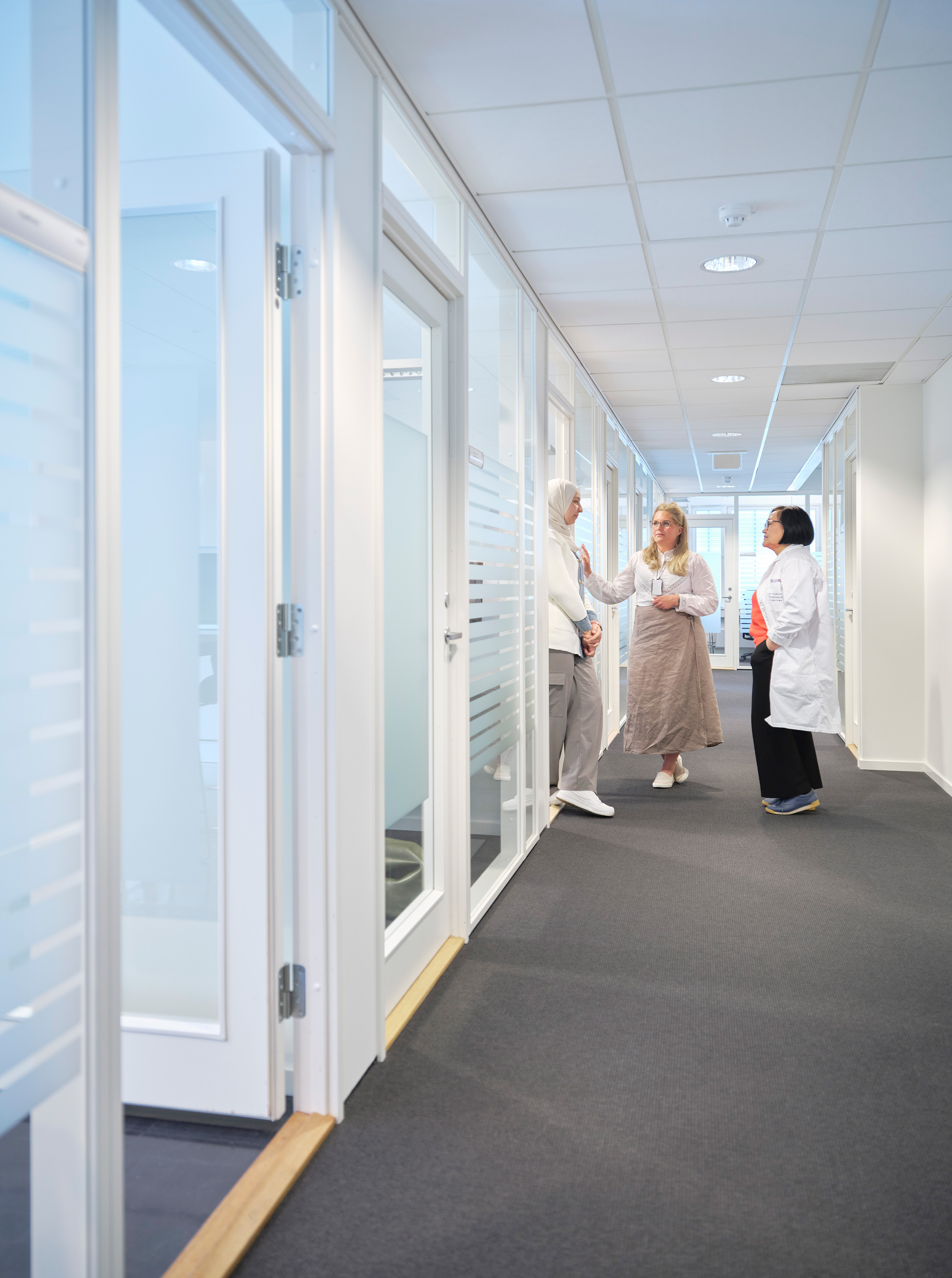Picture of visiting scientists Ikram Salim, Helene Rygvold and Battsetseg Tseveenjav standing in a corridor at NIOM.