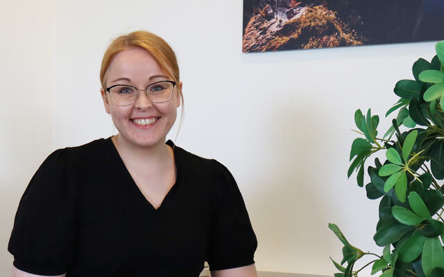 Picture of visiting scientist Saraa Sirkiä sitting in a chair in a corridor at NIOM.