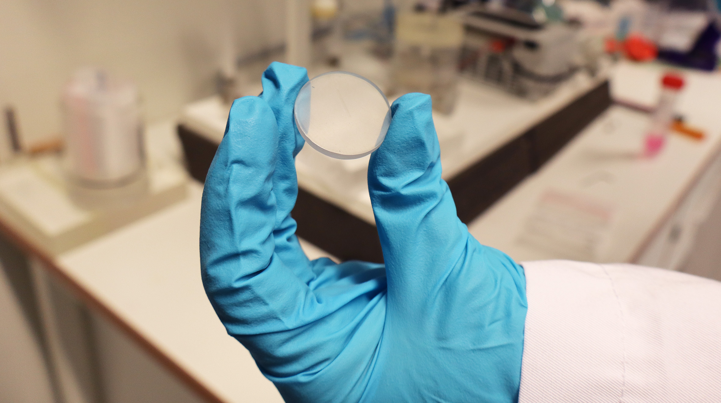 Picture of visiting scientist Kristine Andreassen holding a plast element in her hand.