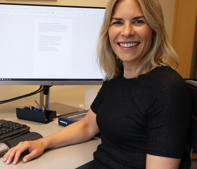 NIOM researcher Mina Aker Sagen sitting in her office next to her PC