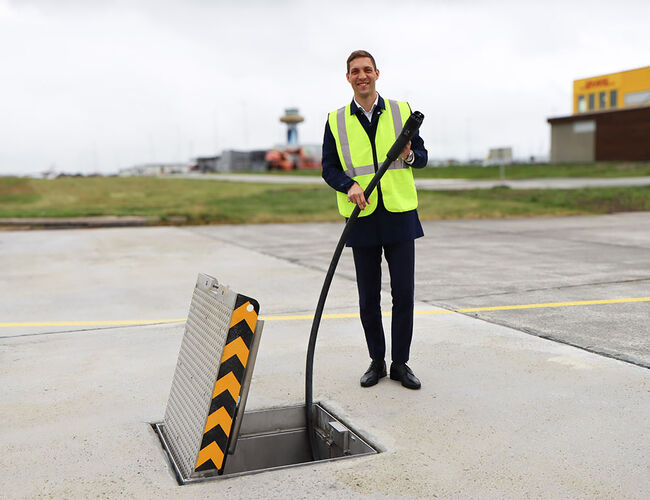 Klima- og miljøminister Andreas Bjelland Eriksen ved den nye elflyladeren på Stavanger lufthavn. Foto: Camilla Walla/Avinor