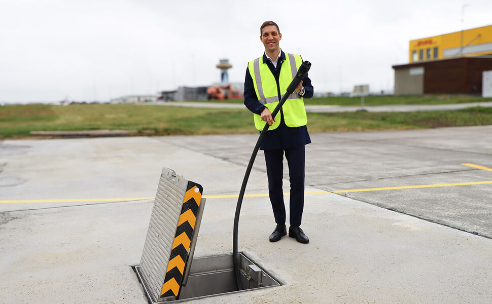 Klima- og miljøminister Andreas Bjelland Eriksen ved den nye elflyladeren på Stavanger lufthavn. Foto: Camilla Walla/Avinor