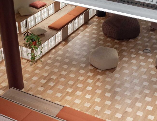 Det er lagt en unik mønsterparkett i byggets første- og andreetasje med overskuddsparkett fra Spjelkavik ungdomsskole og Kongsvinger brannstasjon. Foto: Kyrre Sundal, Mad Arkitekter