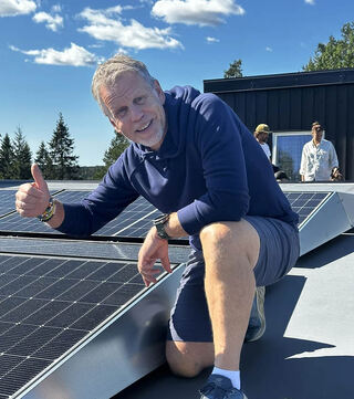 Frank Westlie, daglig leder Vangen Skistua viser tommelen opp for solenergi på taket. Foto: Enny