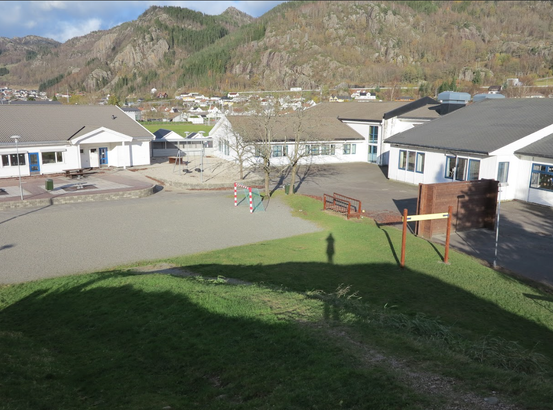 Bilde av flere hvite bygg ute på barneskolen