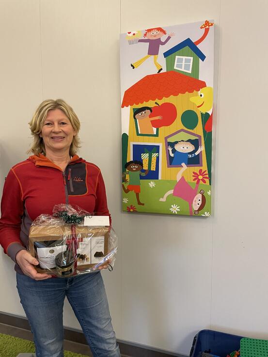 Bilde av dame i rød genser som har mottatt gave for ukas frivillige