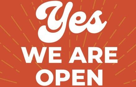 Rød plakat med YES WE ARE OPEN