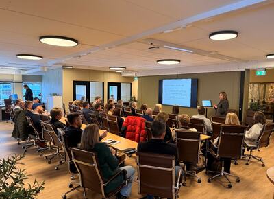 Bildet viser bilde av en gruppe mennesker som sitter i et hyggelig lokale og snakker sammen om bærekraft