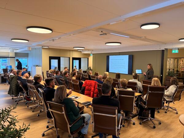 Bildet viser bilde av en gruppe mennesker som sitter i et hyggelig lokale og snakker sammen om bærekraft