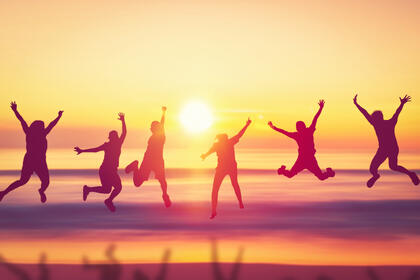 Hoppende mennesker i solnedgang