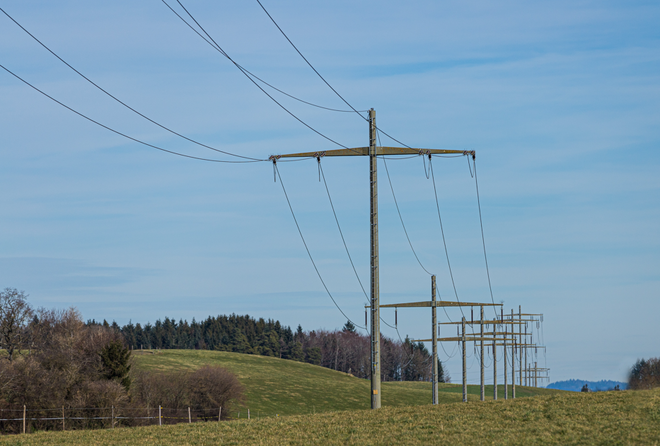 Telefon/strømlinjer over skog og jorder